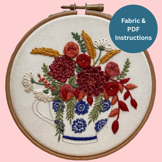 Embroidery hoop with floral design on a pink background, featuring text 'Fabric & PDF Instructions'.