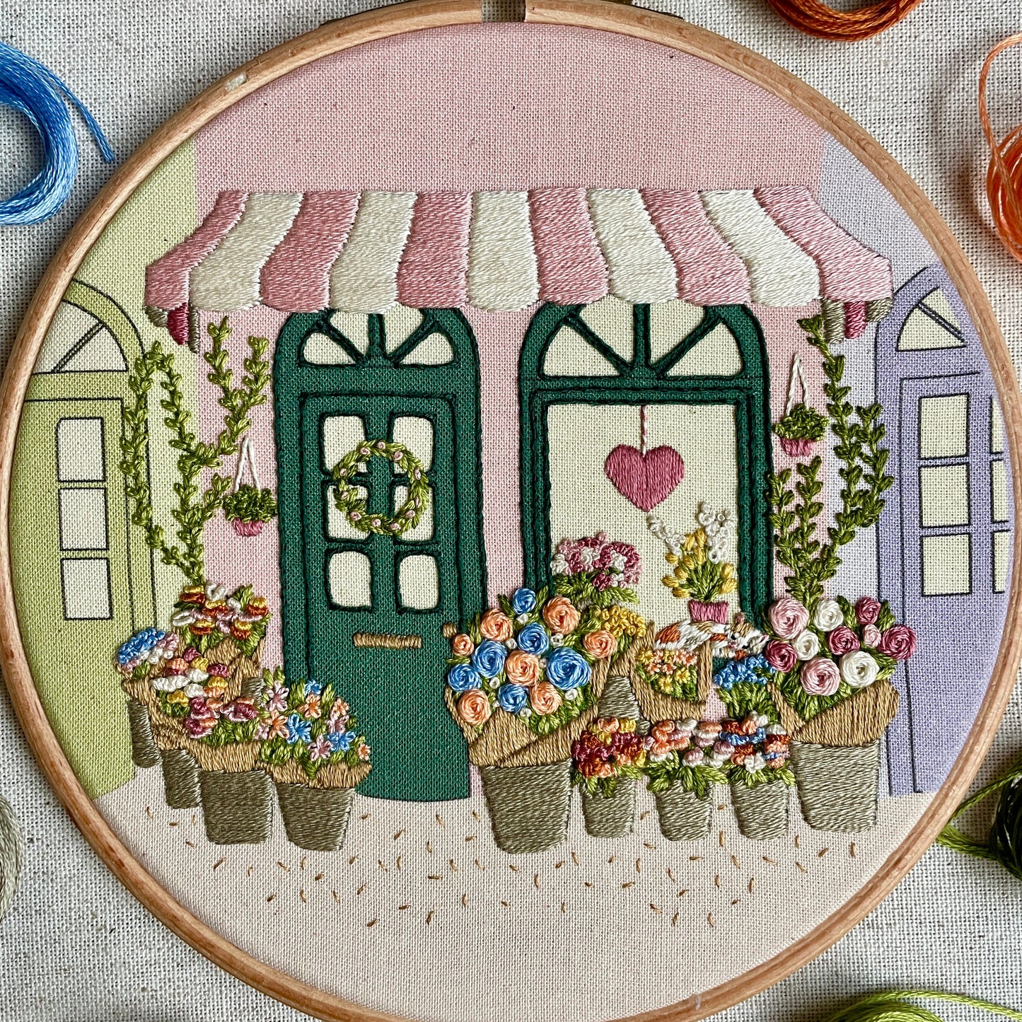 Embroidery hoop with floral design and building background