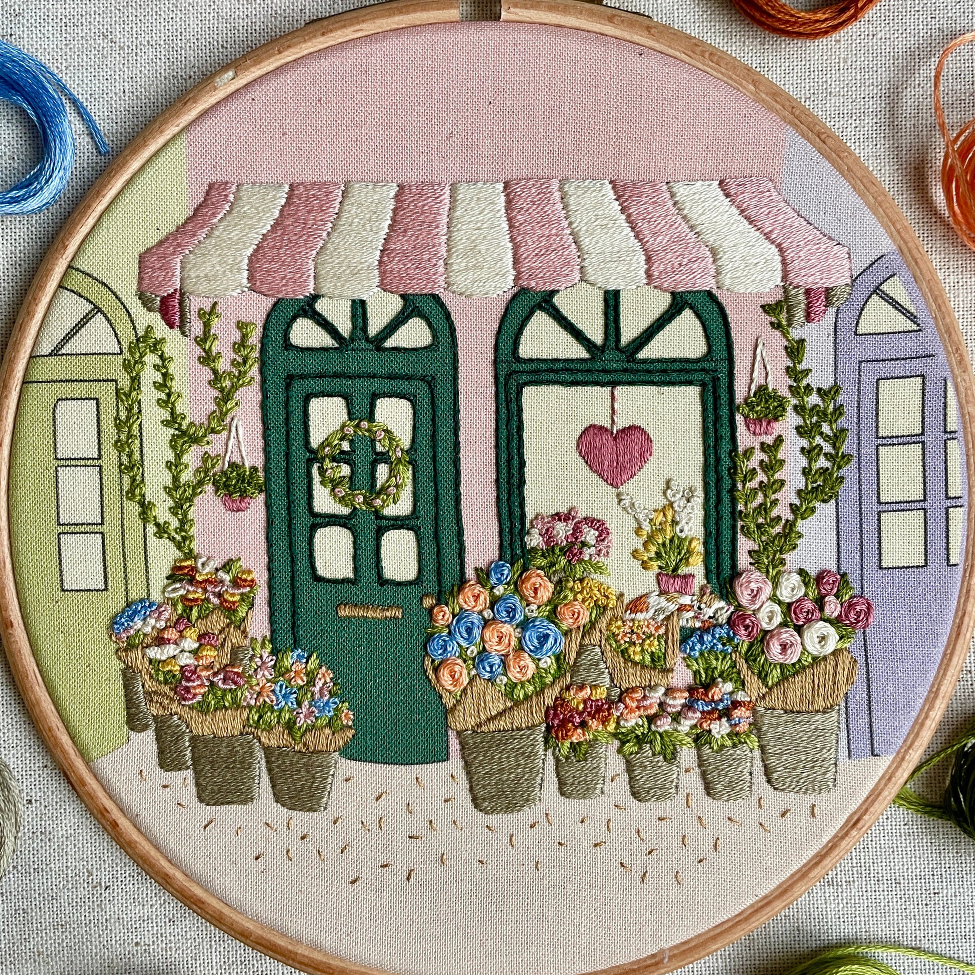 Embroidery hoop with floral design and building background