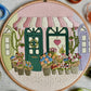 Embroidery hoop with floral design and building background