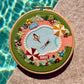 Embroidery hoop with a poolside scene by a pool