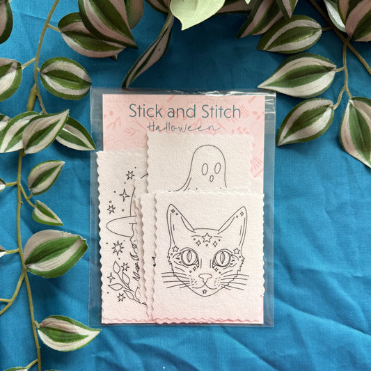 Packaging of 'Stick and Stitch' Halloween designs with a cat and ghost illustration on a blue fabric background.
